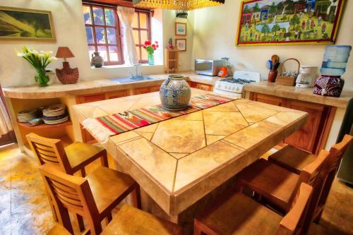 une cuisine avec une grande table et des chaises en bois dans l'établissement Hotel Casa Encantada, à Pátzcuaro