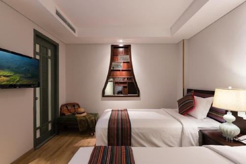 a hotel room with two beds and a lamp at Au Lac Legend Hotel in Ho Chi Minh City