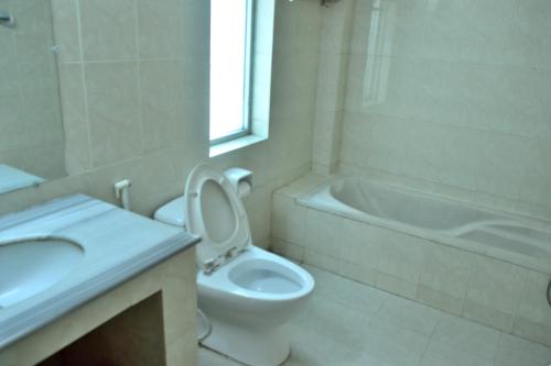 a bathroom with a toilet and a sink and a tub at Inani Royal Resort in Ināni