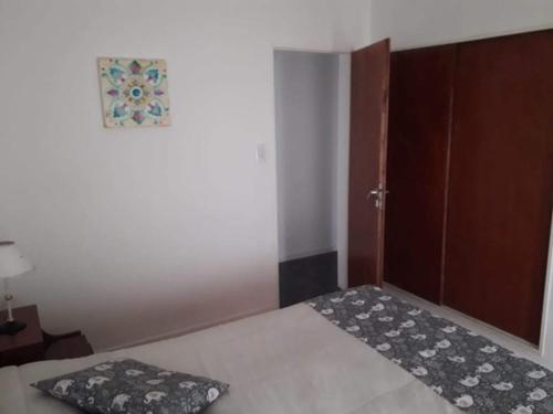 1 dormitorio con cama y puerta con almohada en Venezuela en Tandil