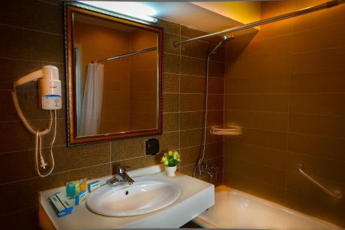 a bathroom with a sink and a mirror and a shower at Park Hotel in Ulaanbaatar