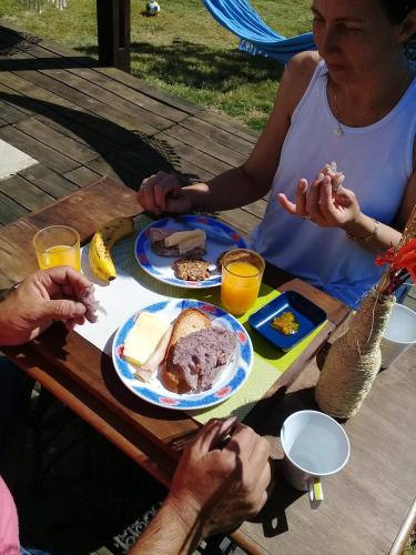 Beleza Pura B&B في بالنيريو بوينس آيرس: مجموعة من الناس يجلسون على طاولة نزهة يأكلون الطعام