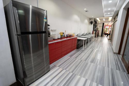 a kitchen with a stainless steel refrigerator and red cabinets at OSS Backpackers Hostel in Singapore