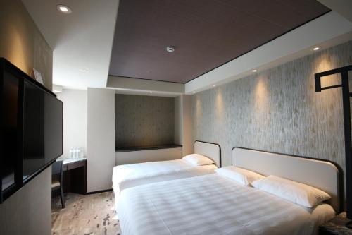 Tempat tidur dalam kamar di Hotel Midtown Richardson - Kaohsiung Bo'ai