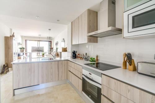 a kitchen with wooden cabinets and a sink at Kaki in San Juan de los Terreros
