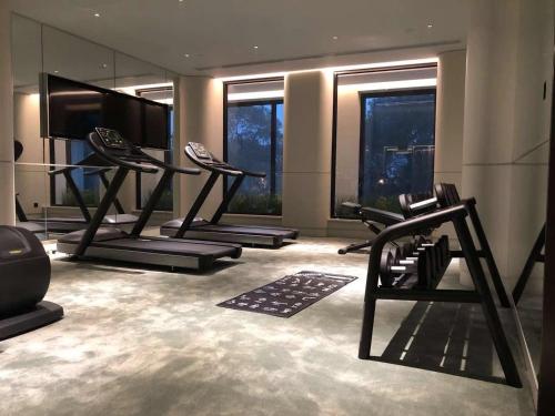 a gym with several tread machines in a room with windows at Mercure Shanghai Hongqiao Central in Shanghai