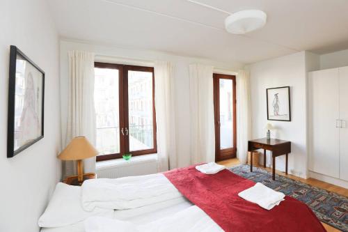 ein Schlafzimmer mit einem großen weißen Bett mit einer roten Decke in der Unterkunft Bright, spacious and trendy apartment in CPH in Kopenhagen