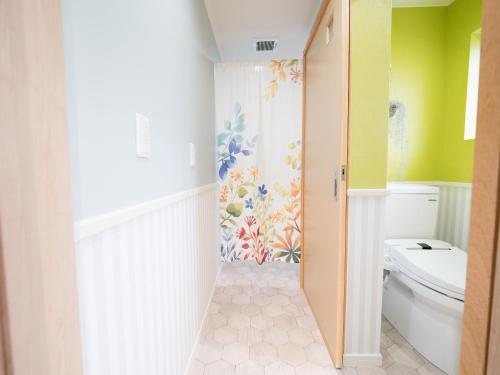 a bathroom with a toilet and a colorful wall at Villa Suite HANA 2Bed room まるまる1棟貸切#北部観光に最適な立地 in Nago