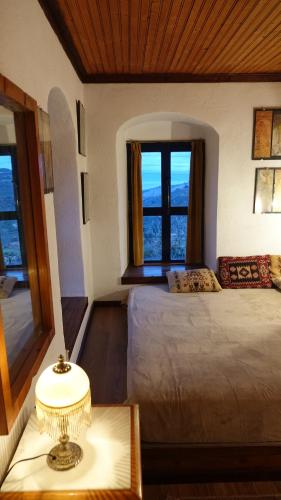 a bedroom with two beds and a window at The old olive mill house in Aegae