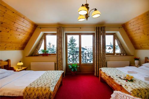 1 dormitorio con 2 camas y ventana en Zakopiański Dwór, en Zakopane