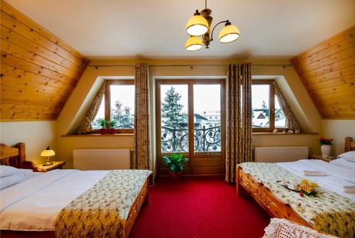 ザコパネにあるZakopiański Dwórのベッドルーム1室(ベッド2台、窓付)