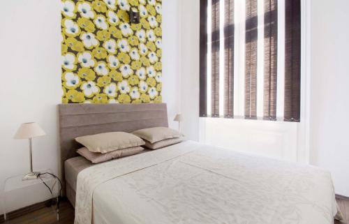 1 dormitorio con 1 cama con pared amarilla y blanca en Andrassy Boulevard, en Budapest