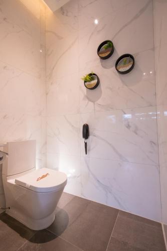 a white bathroom with a toilet and a shower at J Moon Villa Motel in Taipei