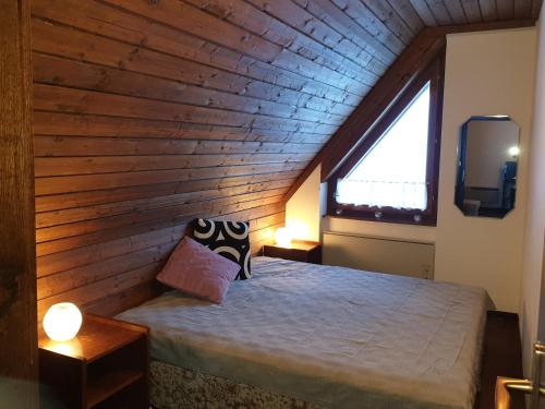 Bett in einem Zimmer mit Holzdecke in der Unterkunft Mountain apartment Innerkrems in Innerkrems