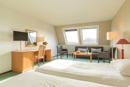 une chambre d'hôtel avec un lit et un salon dans l'établissement Fletcher Hotel-Restaurant Amelander Kaap, à Hollum