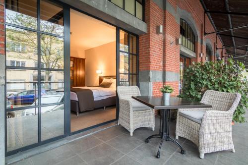 a patio with a table and chairs and a bedroom at Turnhout City Hotel in Turnhout