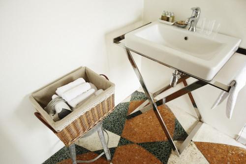 a bathroom with a sink and a basket with towels at Your Fun Apartment in Tainan