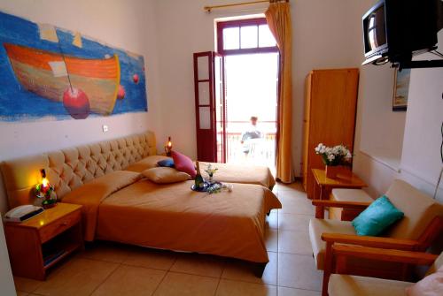 a bedroom with two beds and a couch and a window at Kiniras Traditional Hotel & Restaurant in Paphos