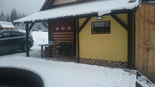 a small cabin with snow on top of it at Chata pod pilskom in Sihelné