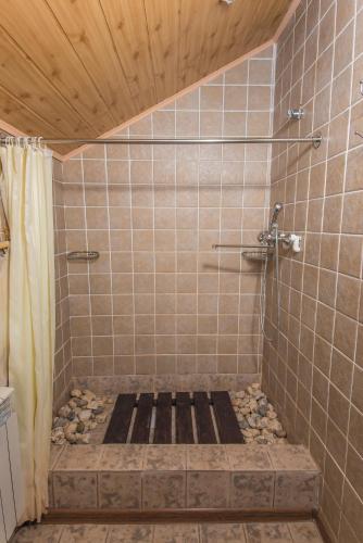 a bathroom with a shower with a stone floor at Boutigue Hotel Nebesa in Chimgan