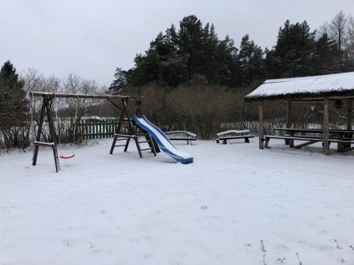 a playground with a slide in the snow at Kihnu Sadama Öömaja Guesthouse in Lemsi