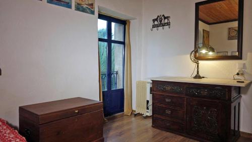 a bedroom with a dresser and a mirror and a window at The old olive mill house in Aegae