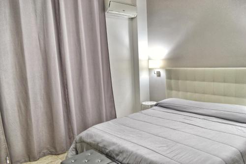 - une chambre avec un lit et une fenêtre avec un rideau dans l'établissement B&B Lungomare, à Catane