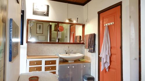 a bathroom with a sink and a red door at The old olive mill house in Aegae