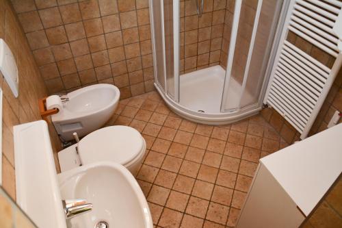a bathroom with a toilet and a sink and a shower at Maso Salim Relax Apartments in Drena