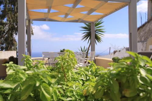 a patio with chairs and a view of the ocean at Ersi Villas in Firostefani