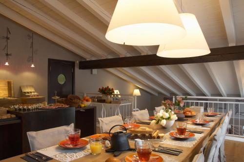 una sala da pranzo con un lungo tavolo e cibo di Hotel Village ad Aosta