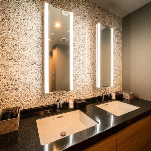 a bathroom with two sinks and two mirrors at Super Hotel Nagano Iida Inter in Iida