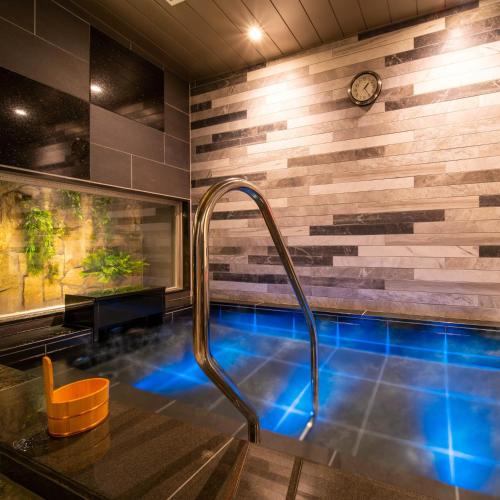 a bathroom with a plunge pool with blue lighting at Super Hotel Nagano Iida Inter in Iida