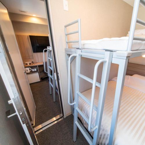 a room with two bunk beds and a mirror at Super Hotel Nagano Iida Inter in Iida