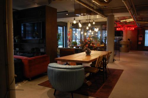 een eetkamer met een houten tafel en stoelen bij Hotel the Match in Eindhoven