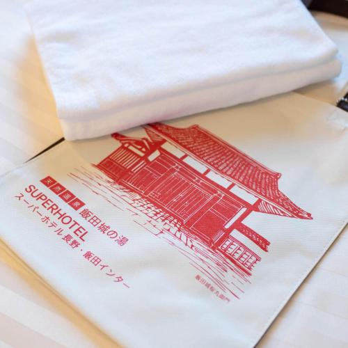 a white napkin with a picture at Super Hotel Nagano Iida Inter in Iida