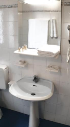 a white bathroom with a sink and a toilet at Hotel Etoile De Neige in Valtournenche