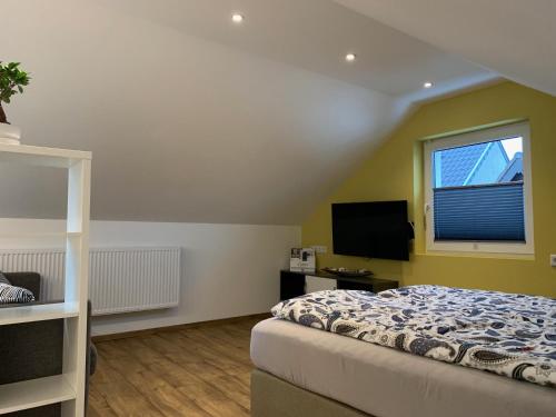 a bedroom with a bed and a window and a television at Apartment Köln Ensen in Cologne