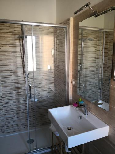 a bathroom with a sink and a glass shower at Michelangelo Home B&B in Rossano