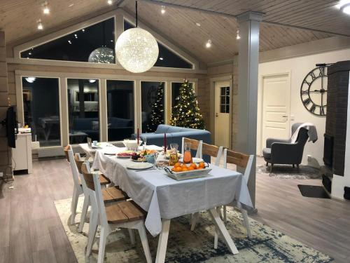 a dining room with a table and a christmas tree at Villa Avanto in Suomenniemi