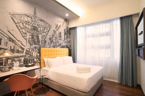 a bedroom with a bed and a desk and a drawing on the wall at Travelodge Kuala Lumpur City Centre in Kuala Lumpur