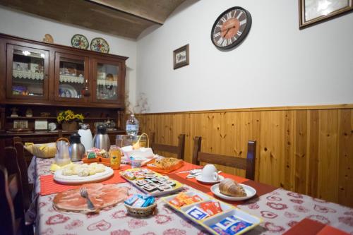 a table with food on it with a clock on the wall at Bed and Breakfast Misghecchino in Foligno