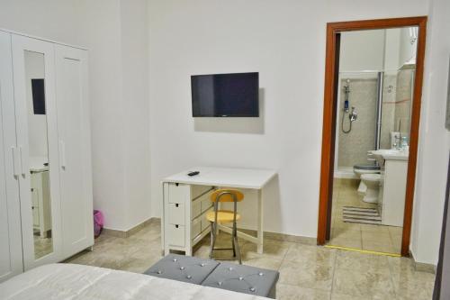 a white bedroom with a desk and a bathroom at B&B Lungomare in Catania