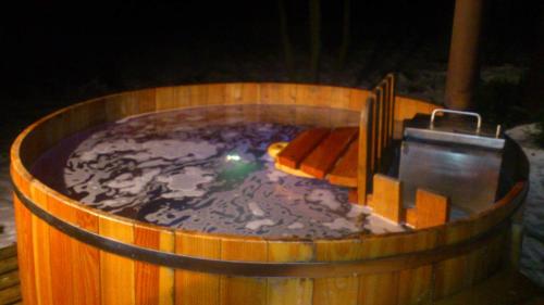 a large wooden tub filled with a hot tub at Chata pod pilskom in Sihelné