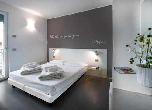 Un dormitorio con una cama blanca con toallas. en Gardabike Residence, en Nago-Torbole