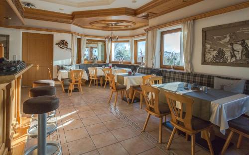 ein Restaurant mit Tischen und Stühlen in einem Zimmer in der Unterkunft Landhaus Alpenherz in Aschau
