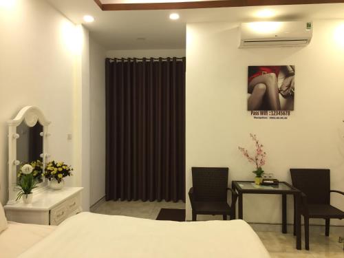 a bedroom with a bed and a table and chairs at HD House in Noi Bai