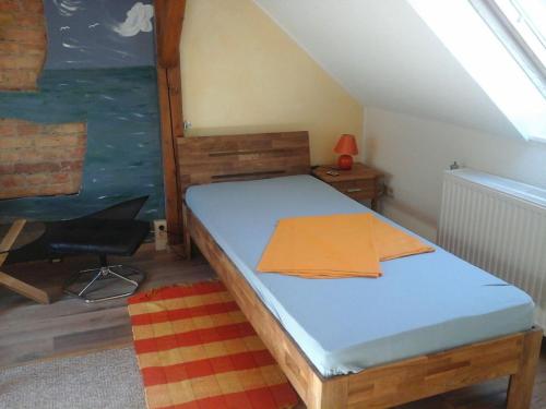 1 dormitorio pequeño con 1 cama y 1 silla en JaNettes Gästehaus en Bad Doberan