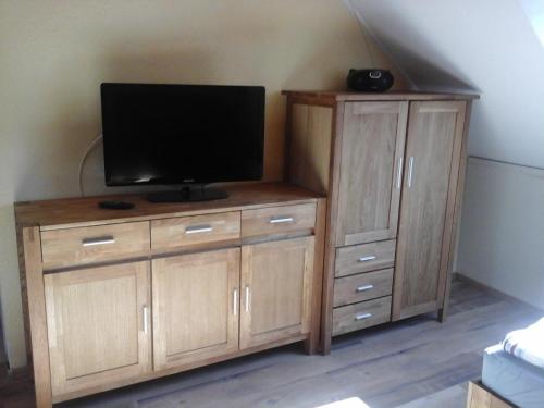 a wooden entertainment center with a flat screen tv on it at JaNettes Gästehaus in Bad Doberan