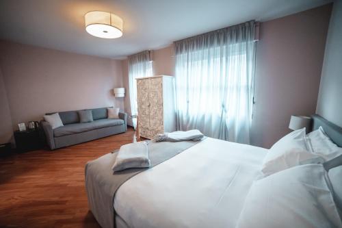 a bedroom with a large bed and a couch at Casa Agnese in Alba